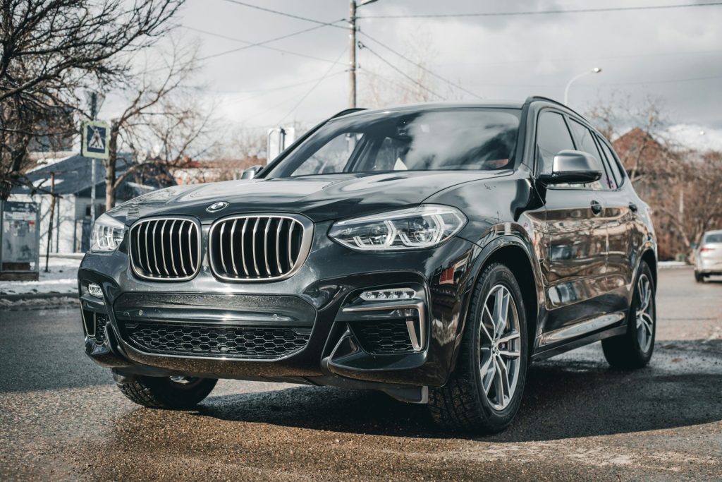 a black bmw suv parked in a parking lot